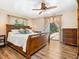 Cozy main bedroom featuring hardwood floors, wooden furniture, neutral tones, and sliding glass doors leading to the patio at 6308 Caracara St, Sarasota, FL 34241
