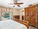 Bright main bedroom features a ceiling fan, an ensuite bathroom, and patio access to a refreshing pool at 6308 Caracara St, Sarasota, FL 34241