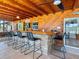 Outdoor brick bar with seating offers a relaxed experience on the screened in porch with wood plank ceiling at 6308 Caracara St, Sarasota, FL 34241