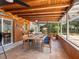 Inviting patio dining area with natural wood plank ceiling and views to the greenery in the back yard at 6308 Caracara St, Sarasota, FL 34241