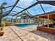 Screened-in pool with brick patio, landscaping, and open views, perfect for outdoor relaxation at 6308 Caracara St, Sarasota, FL 34241