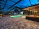 Beautifully lit in-ground pool surrounded by brick pavers and a screened enclosure for year-round enjoyment at 6308 Caracara St, Sarasota, FL 34241