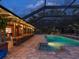 Stunning screened-in pool area featuring brick patio, connecting bar and lush surroundings for ultimate privacy at 6308 Caracara St, Sarasota, FL 34241