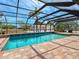 Refreshing screened-in pool featuring a brick patio, landscaping, and backyard views at 6308 Caracara St, Sarasota, FL 34241