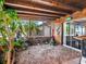 Enclosed sunroom featuring wood paneling, decorative accents, and views of the landscaped backyard at 6308 Caracara St, Sarasota, FL 34241