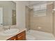 Well-lit bathroom featuring a shower and bathtub with stylish beige tiling and a wood vanity at 6310 Golden Eye Gln, Lakewood Ranch, FL 34202