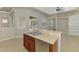 Kitchen island featuring a stainless steel dishwasher and double sink with wood cabinets at 6310 Golden Eye Gln, Lakewood Ranch, FL 34202