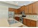 Kitchen with stainless steel appliances, wood cabinets, tile backsplash and island with sink at 6310 Golden Eye Gln, Lakewood Ranch, FL 34202