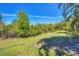 The large backyard features open green space bordered by trees, creating a natural buffer for privacy and tranquility at 6510 Flycatcher Ln, Lakewood Ranch, FL 34202