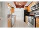 Galley kitchen featuring wooden cabinets, stainless steel appliances, and tile floors at 6813 7Th W Ave, Bradenton, FL 34209