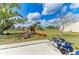 Spacious backyard with a playset, slide, and ride-on toy vehicles at 7002 Primm Pl, North Port, FL 34287