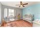 Brightly colored Bedroom with hardwood floors, a crib, and a decorative toy giraffe at 7002 Primm Pl, North Port, FL 34287