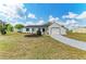 Cozy single-story residence with a green lawn, complemented by neatly arranged flower beds and an attached garage at 7002 Primm Pl, North Port, FL 34287