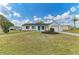 Inviting single-story home featuring a well-kept lawn, vibrant flower beds, and a bright blue front door at 7002 Primm Pl, North Port, FL 34287