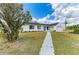 Charming single-story home boasts a manicured lawn, flower beds, and a welcoming walkway at 7002 Primm Pl, North Port, FL 34287