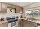 Well-maintained kitchen area featuring wooden cabinetry, stainless steel appliances, and granite counters at 7002 Primm Pl, North Port, FL 34287