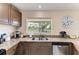 Kitchen with granite countertops, stainless steel sink, wooden cabinets and a bright window overlooking the yard at 7002 Primm Pl, North Port, FL 34287