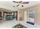 Spacious area with a dining table in the background and an outdoor view through the glass doors at 7002 Primm Pl, North Port, FL 34287