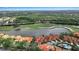 Stunning aerial view overlooking red-roofed homes, a serene lake, and a lush green golf course at 7309 Regina Royale Blvd # 21, Sarasota, FL 34238