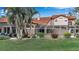 Beautiful backyard with screened-in patio, lush lawn, and mature tropical landscaping at 7309 Regina Royale Blvd # 21, Sarasota, FL 34238