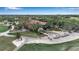 Aerial view of the clubhouse surrounded by lush greenery and golf carts, offering scenic views in a serene setting at 7309 Regina Royale Blvd # 21, Sarasota, FL 34238
