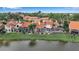 Aerial view of a home with a pool, screened-in patio, lush backyard, and waterfront view at 7309 Regina Royale Blvd # 21, Sarasota, FL 34238