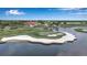 Beautiful golf course view with meticulously manicured green, white sand traps, and a central red-roofed clubhouse by a pond at 7309 Regina Royale Blvd # 21, Sarasota, FL 34238