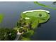 Picturesque aerial view of an island golf green surrounded by water, showcasing meticulous landscaping and serene beauty at 7309 Regina Royale Blvd # 21, Sarasota, FL 34238