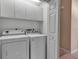 Bright laundry room features a white washer and dryer, along with built-in cabinets for ample storage at 7309 Regina Royale Blvd # 21, Sarasota, FL 34238