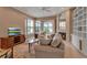 Bright living room featuring a fireplace, tan tile flooring, and sliding glass doors with lake views at 7309 Regina Royale Blvd # 21, Sarasota, FL 34238