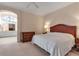 Inviting main bedroom featuring wooden furnishings on carpeted floor and view into adjacent room at 7309 Regina Royale Blvd # 21, Sarasota, FL 34238