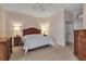 Spacious main bedroom with neutral walls, a ceiling fan, and coordinating wooden furnishings on carpeted floor at 7309 Regina Royale Blvd # 21, Sarasota, FL 34238