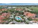Overhead view of the community pool, spa, parking, landscaping, and nearby red-roofed homes at 7309 Regina Royale Blvd # 21, Sarasota, FL 34238