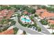 Aerial view of a community pool, spa, parking, landscaping, and surrounding tile-roofed homes at 7309 Regina Royale Blvd # 21, Sarasota, FL 34238