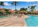 A tranquil outdoor pool and spa surrounded by tropical foliage and red-roofed residential buildings at 7309 Regina Royale Blvd # 21, Sarasota, FL 34238