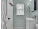 This bathroom features a white vanity, a window with a sheer curtain, and light blue walls at 807 Harbor Ave, Ellenton, FL 34222