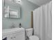 Clean bathroom with white vanity, mirror, toilet, and shower curtain at 807 Harbor Ave, Ellenton, FL 34222