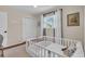Cozy bedroom with natural light, featuring a white crib, bi-fold closet doors, and neutral walls at 807 Harbor Ave, Ellenton, FL 34222