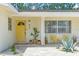 Inviting front porch features a bright yellow door, potted plants, and chairs for relaxing at 807 Harbor Ave, Ellenton, FL 34222
