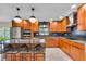 Modern kitchen with gray counters, wood cabinets, island with seating, and stainless appliances at 807 Harbor Ave, Ellenton, FL 34222