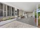 Spacious covered patio with neutral tones, white railings, and a decorative white brick base with green plants at 8517 Buckingham Pl, Palmetto, FL 34221
