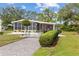 Charming home with screened in porch, driveway, and beautiful landscaping featuring well maintained bushes and grass at 8517 Buckingham Pl, Palmetto, FL 34221