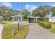 Charming home featuring a long drive and landscaped front yard, complemented by mature trees and a screened-in porch at 8517 Buckingham Pl, Palmetto, FL 34221