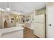 Bright eat-in kitchen featuring modern appliances, and tile countertops, adjacent to back door and large refrigerator at 8517 Buckingham Pl, Palmetto, FL 34221