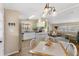 Bright, open kitchen with modern light fixtures, white cabinets, stone countertops, and a seamless view into the living room at 8517 Buckingham Pl, Palmetto, FL 34221