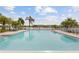 Outdoor pool with lounge seating and partial lake view, perfect for relaxing and enjoying the sunny weather at 8517 Buckingham Pl, Palmetto, FL 34221