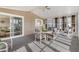 This is a well-lit sunroom with large windows, neutral carpet and seating for four around a round table at 8517 Buckingham Pl, Palmetto, FL 34221