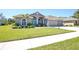 Charming home with arched windows, a bright blue door, and a well-manicured lawn at 8615 59Th E St, Parrish, FL 34219