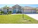 Charming home with arched windows, a bright blue door, and a well-manicured lawn at 8615 59Th E St, Parrish, FL 34219