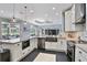 Modern kitchen featuring granite countertops, stainless steel appliances, and white cabinetry overlooking the living area at 8615 59Th E St, Parrish, FL 34219
